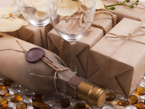 a bottle of wine on its side surrounded by craft-paper wrapped presents